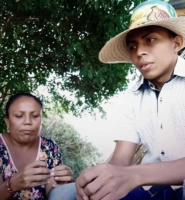 Adolescente indígena sentado junto a una  mujer indígena adulta