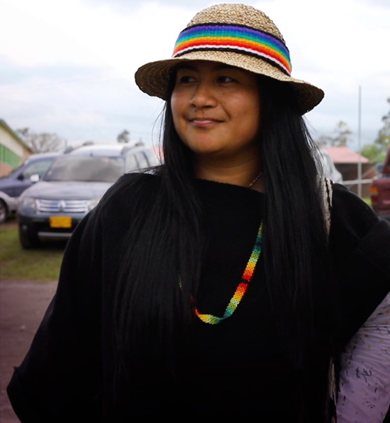 mujer indígena joven sonriendo con prendas tradicionales indígenas