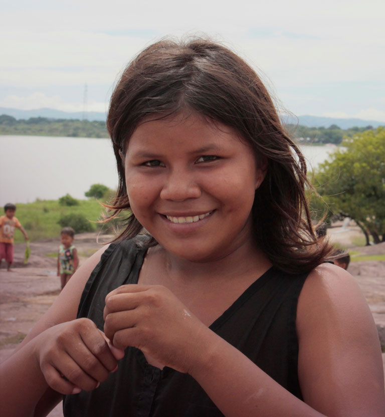 Adolescente Amorúa sonriendo con algunos niños detrás de ella