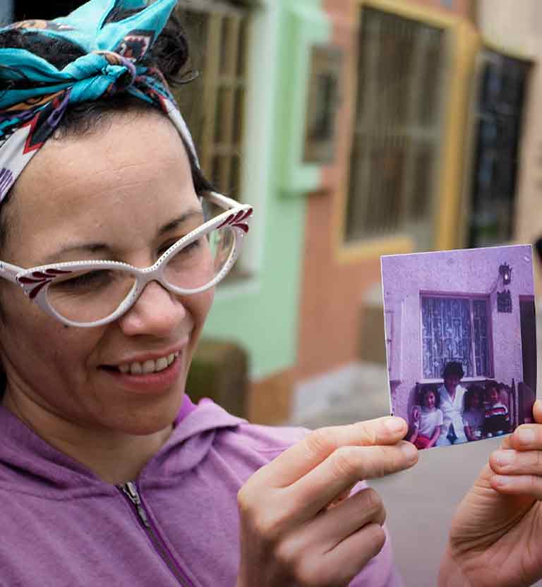 Mujer joven sonriendo y mostrando una fotografía - Clara