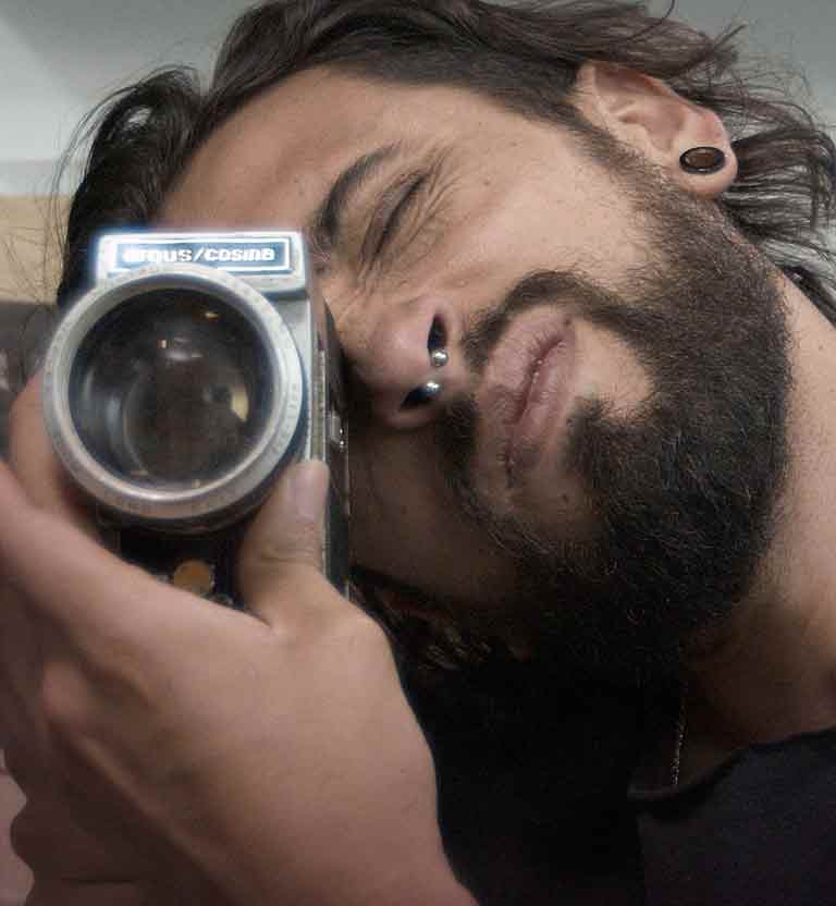 Joven mirando por el visor de una cámara antigua