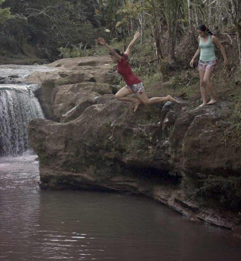 Dos niñas adolescentes saltando al río en la selva - La Promesa