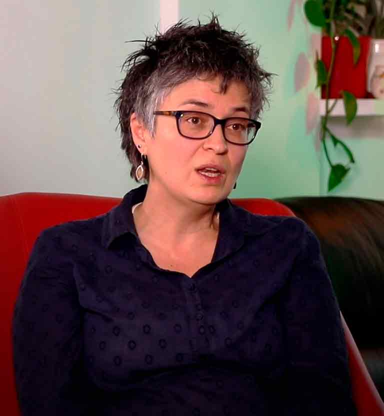 Mujer adulta conversando sentada en un sillón