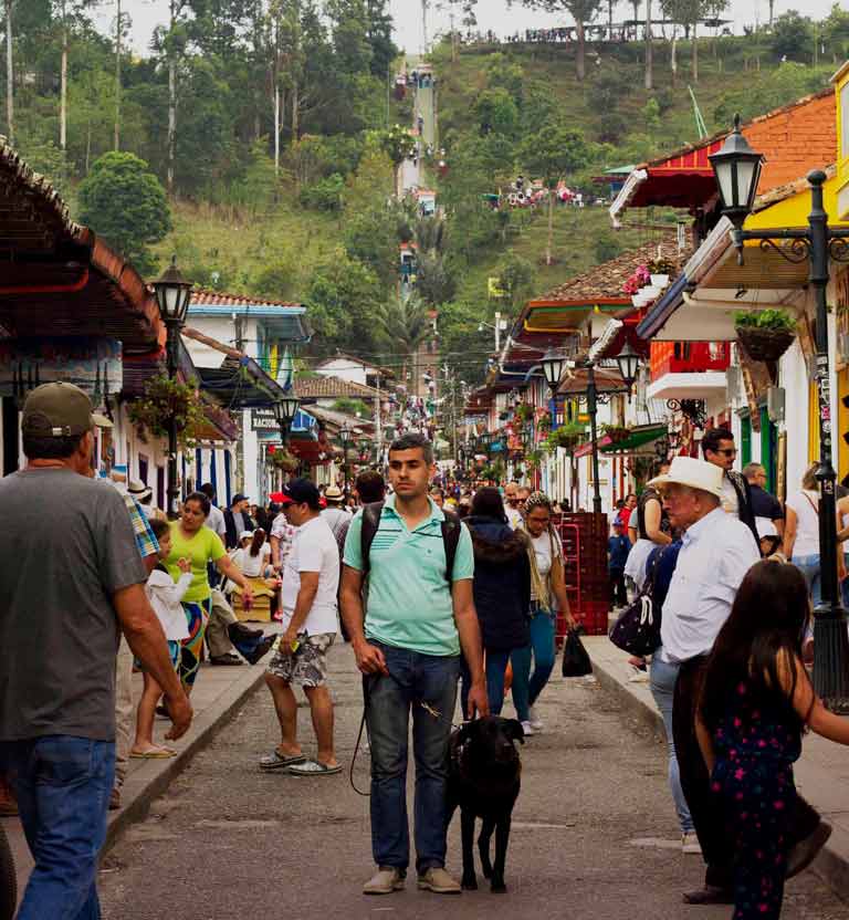 Hombre con discapacidad visual caminando por la calle principal de Salento