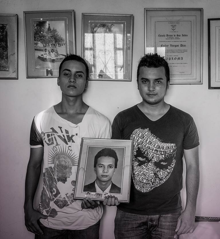 Dos jóvenes sostienen la fotografía de su padre en las manos Shooting película documental Señal Colombia