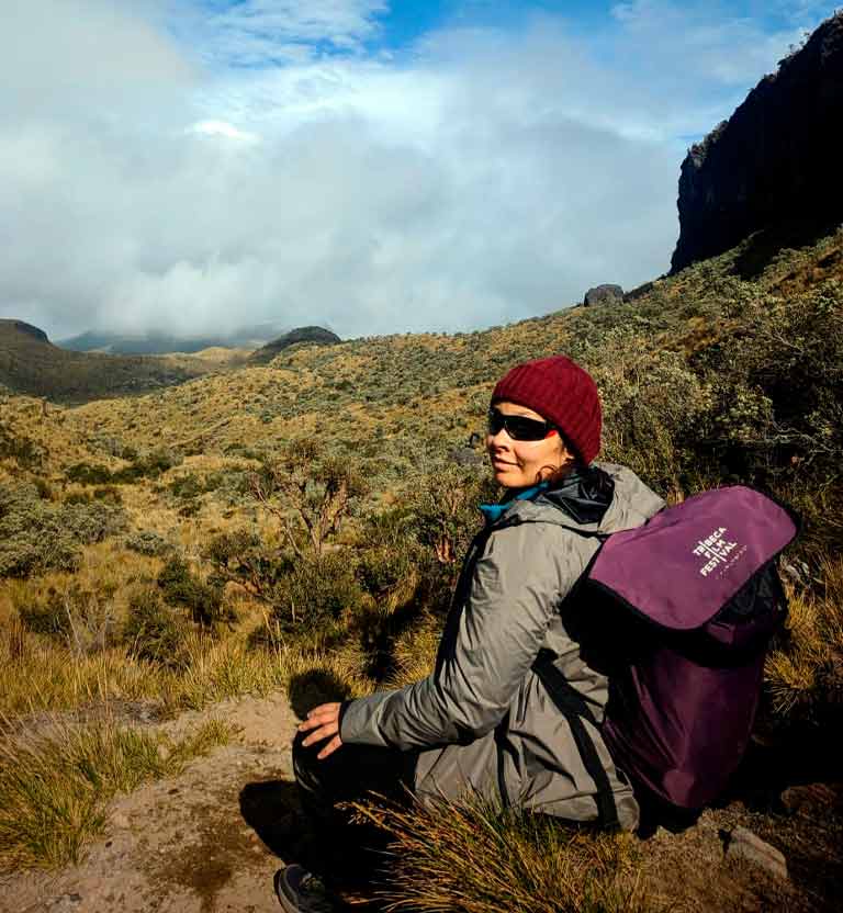 mujer adulta sentada en una roca de la montaña de un nevado