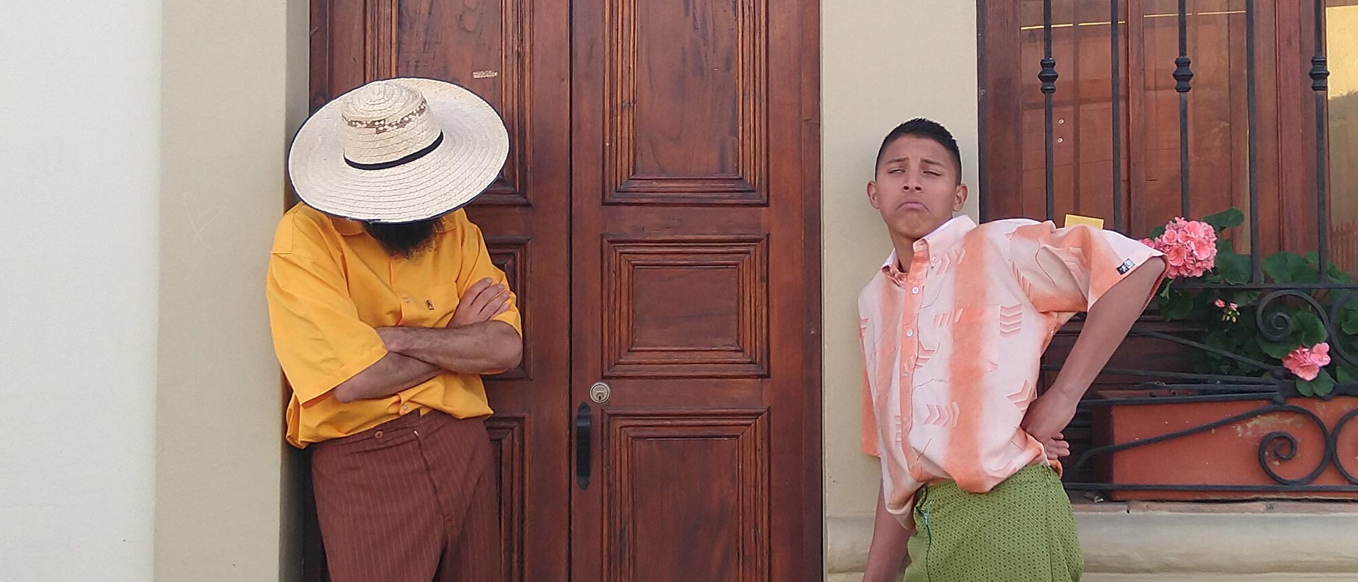 Dos hombres parados junto a una puerta de madera - 80 años con voz