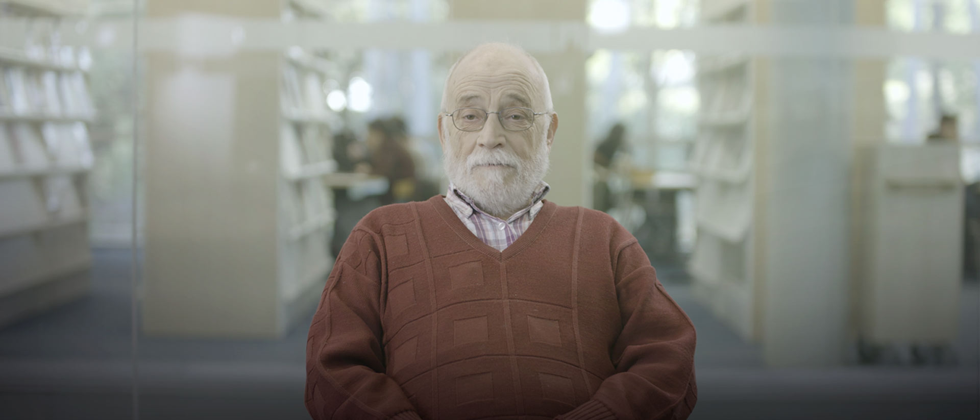 adulto mayor sentado con gafas en una biblioteca