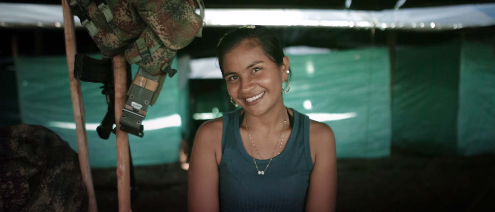 Mujer guerrillera sonriendo en un cambuche