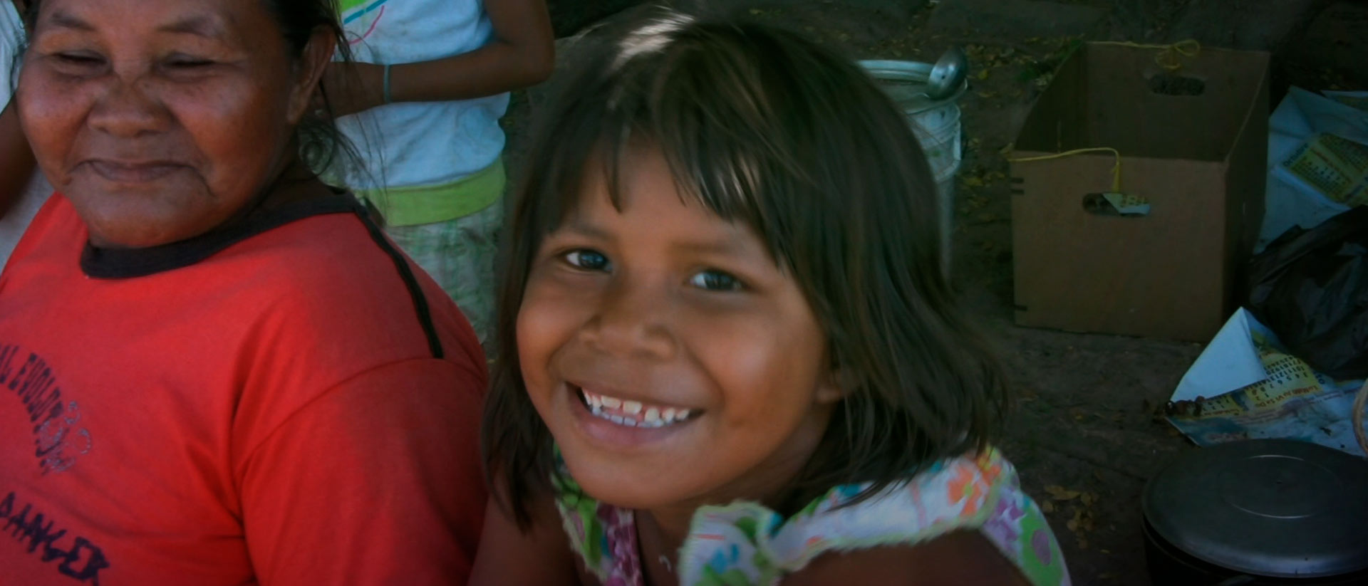 Niña indígena del pueblo Amorúa sonriendo al lado de su abuela 
