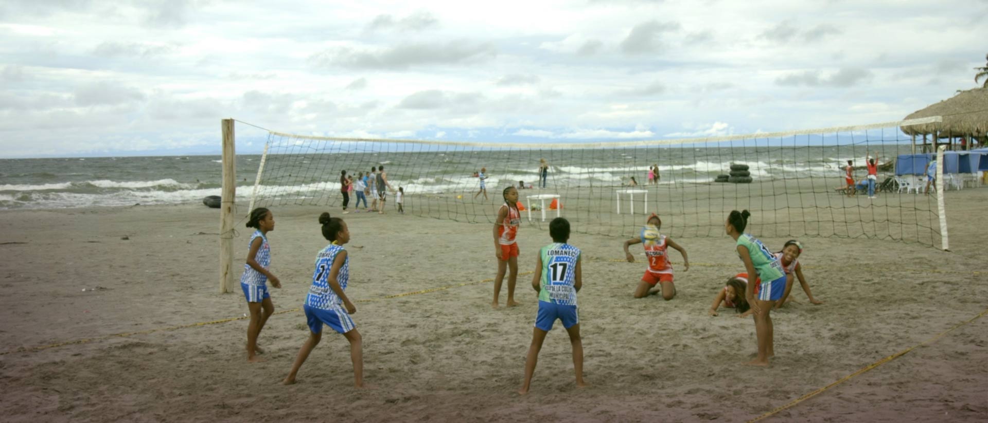 Dos grupos de niñas jugando voleibol en la playa