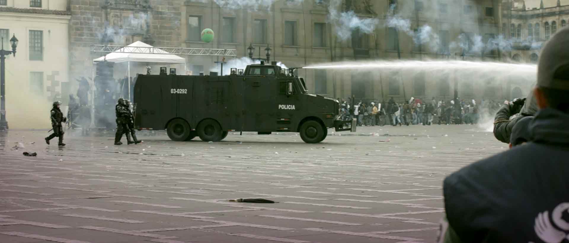 Policía del ESMAD con una tanqueta lanzando un chorro de agua en la calle durante una manifestación - - Mediador, entre todos los fuegos
