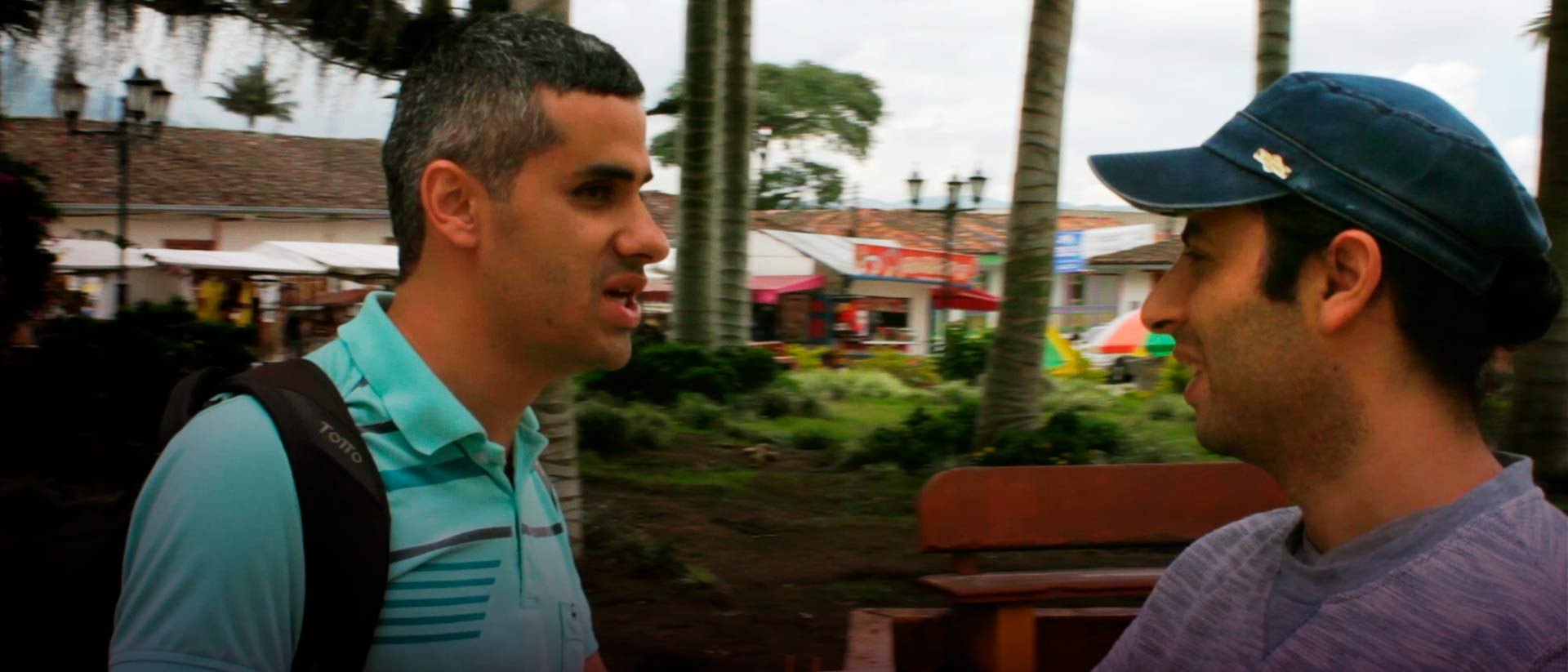 Hombre con discapacidad visual hablando con un joven en la plaza de Salento