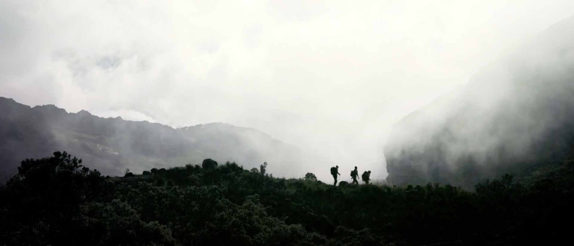 tres personas ascendiendo por una montaña en un nevado