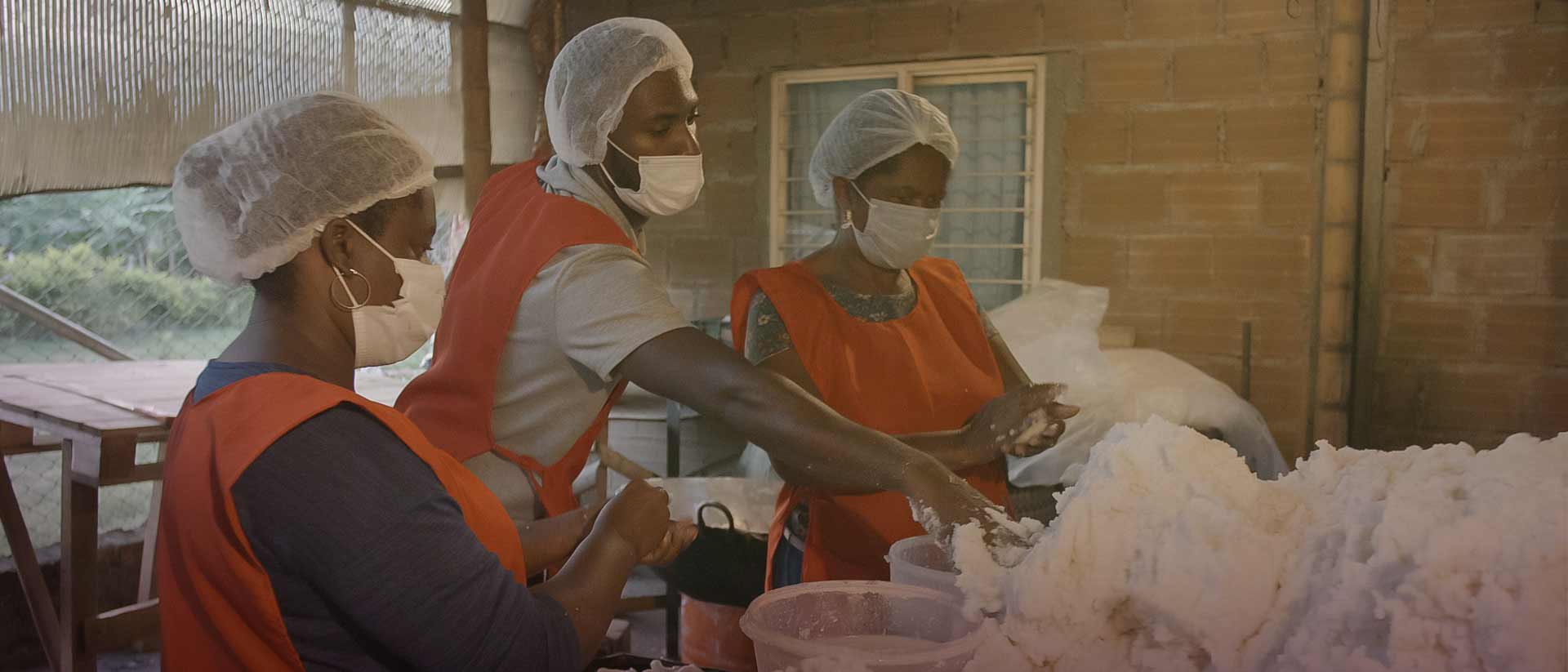 Tres personas afrocolombianas trabajando con harina de maíz 