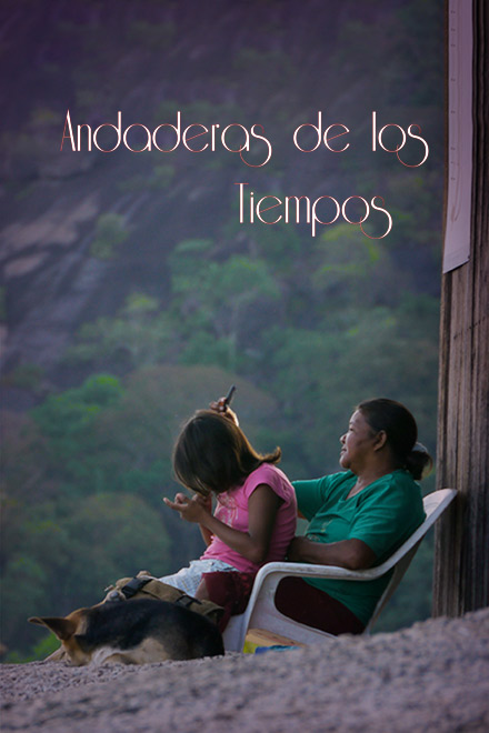 Abuela indígena del pueblo Amorúa peinando a su nieta sobre las piernas al lado de un perro