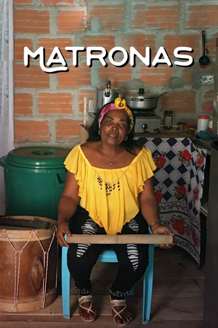 mujer afrodescendiente sentada en una silla al lado de la cocina con instrumentos musicales a su alrededor