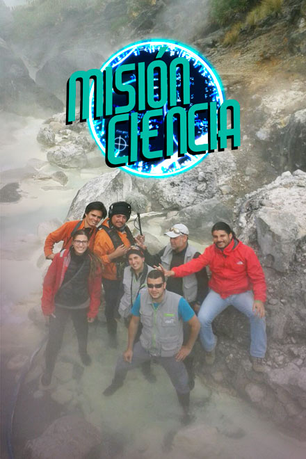 Grupo de personas sonriendo para un foto en un ambiente rocoso, frío, nublado.