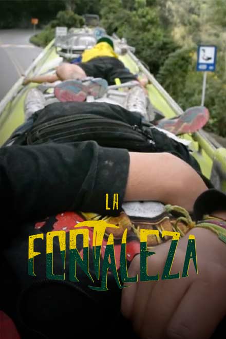 Dos hinchas jóvenes acostados sobre un bus viajando por carretera - La fortaleza