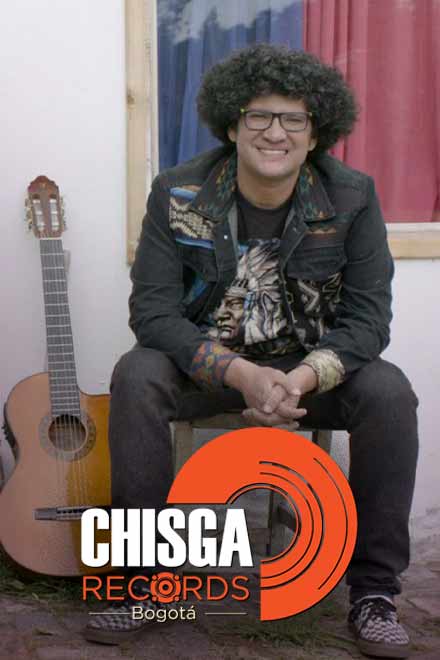 Musico joven sentado con una guitarra al lado.