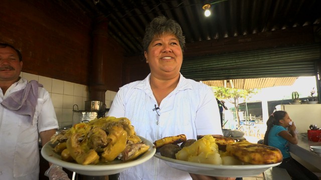 señora con dos platos de gallina criolla
