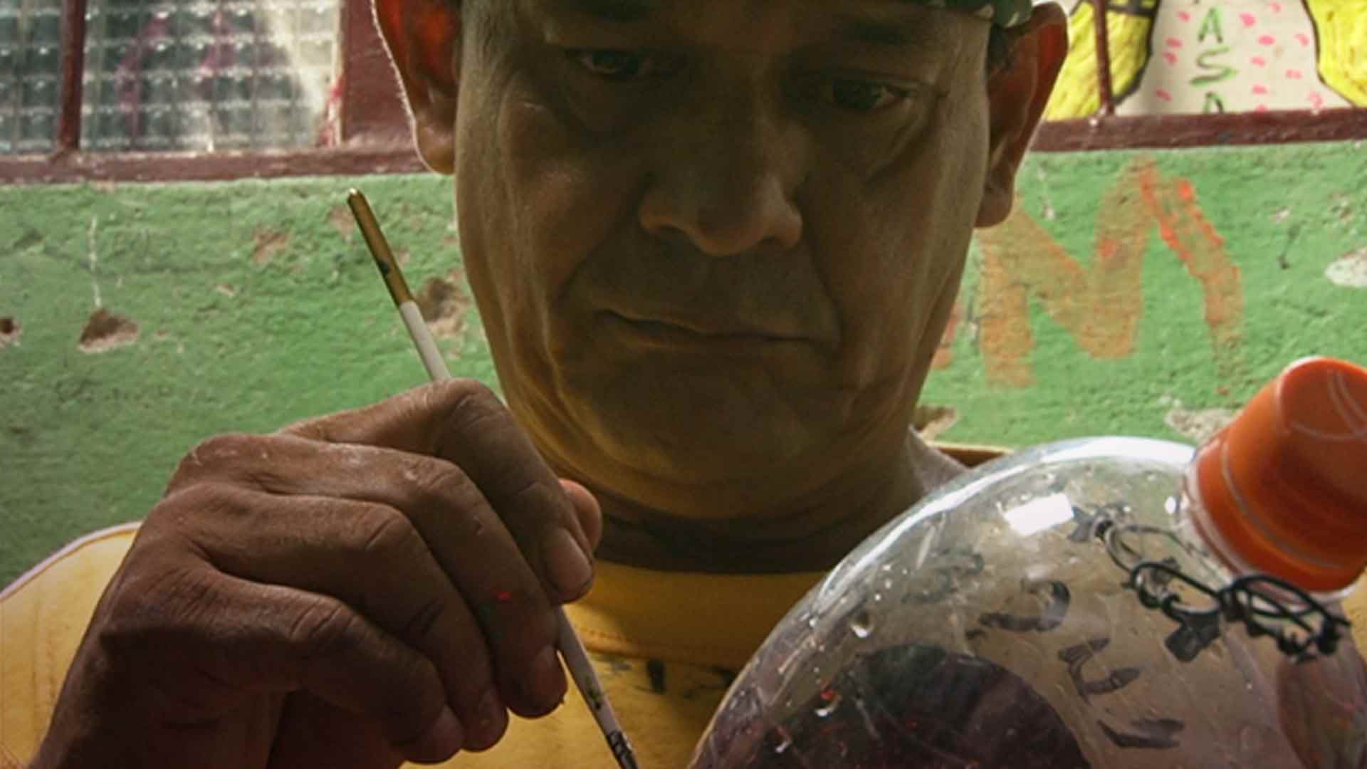 hombre pintando una botella plástica