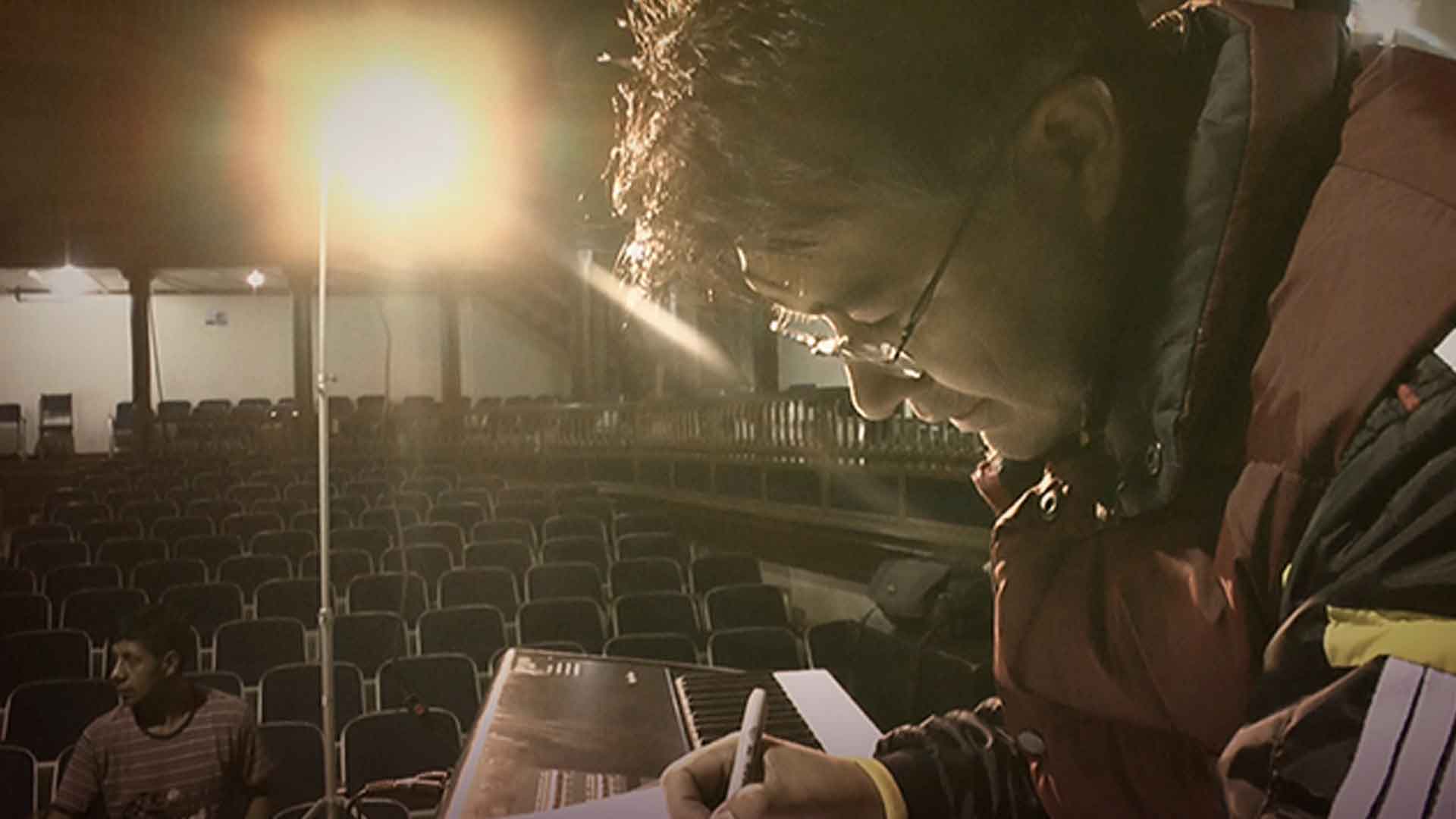 Hombre escribiendo sobre el piano en un auditorio