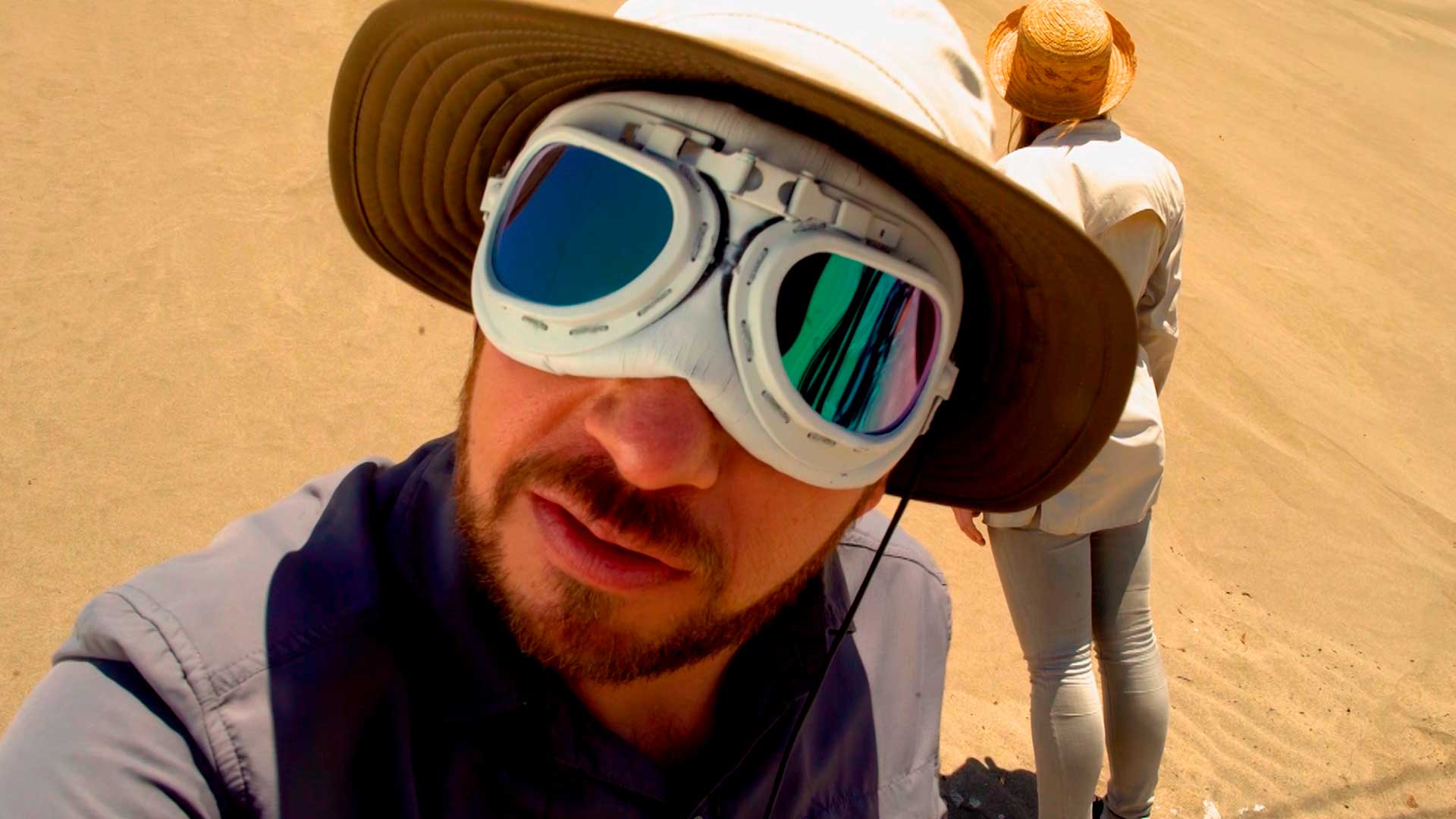 Hombre con gafas exploradoras y sombrero en el desierto 