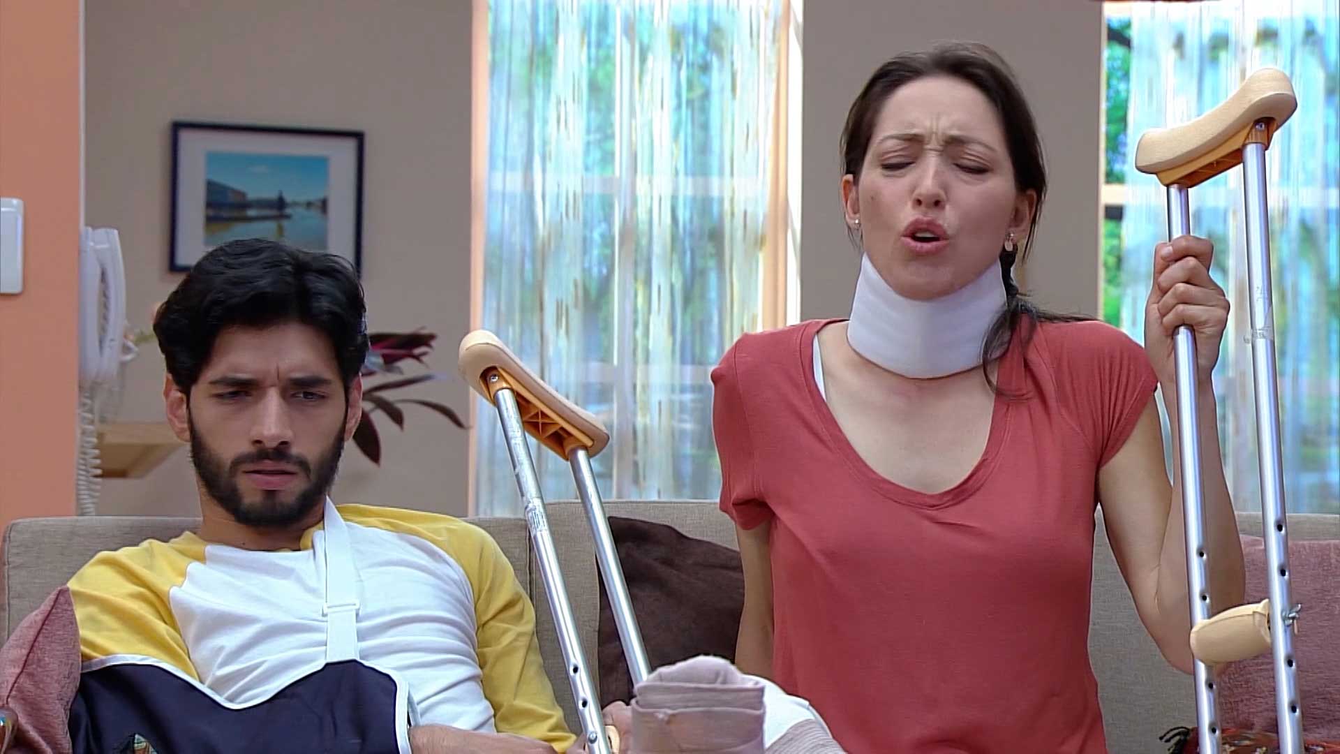 mujer con cuello ortopédico y muletas con un hombre