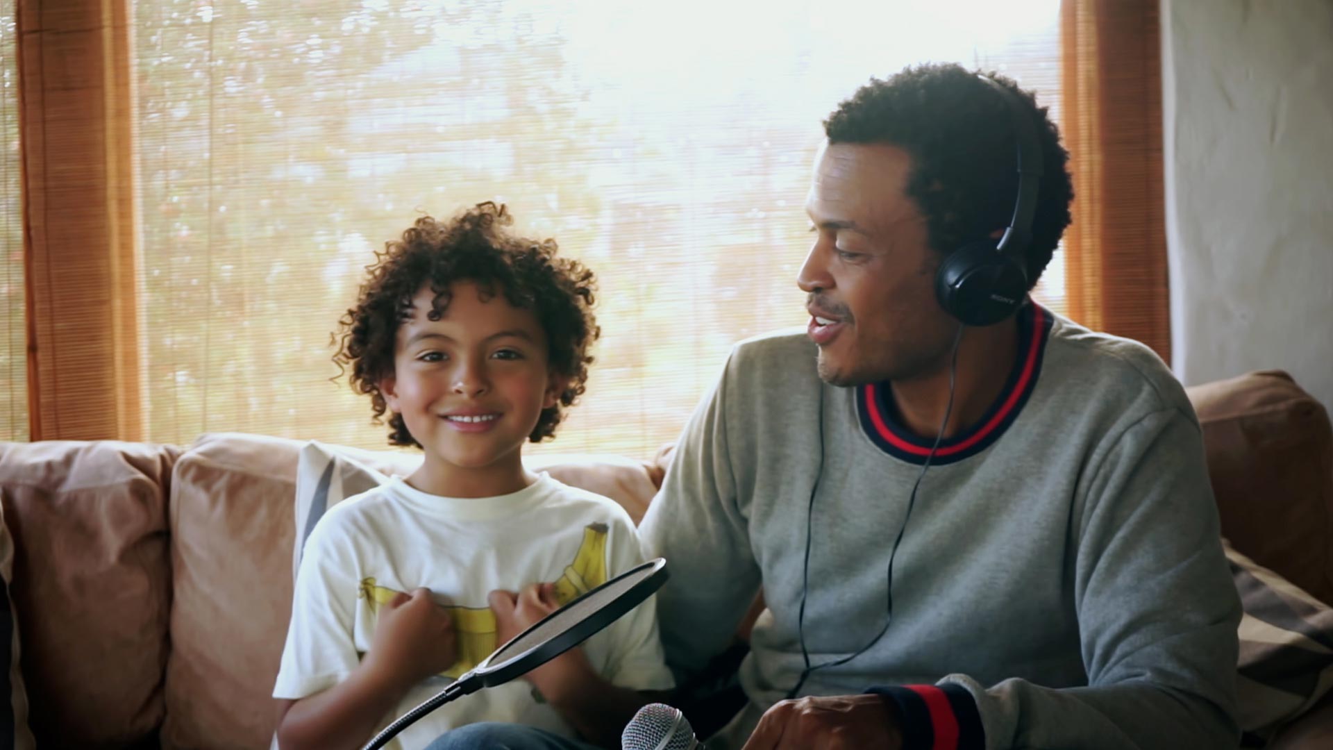 Padre e hijo escuchando algo con audífonos 
