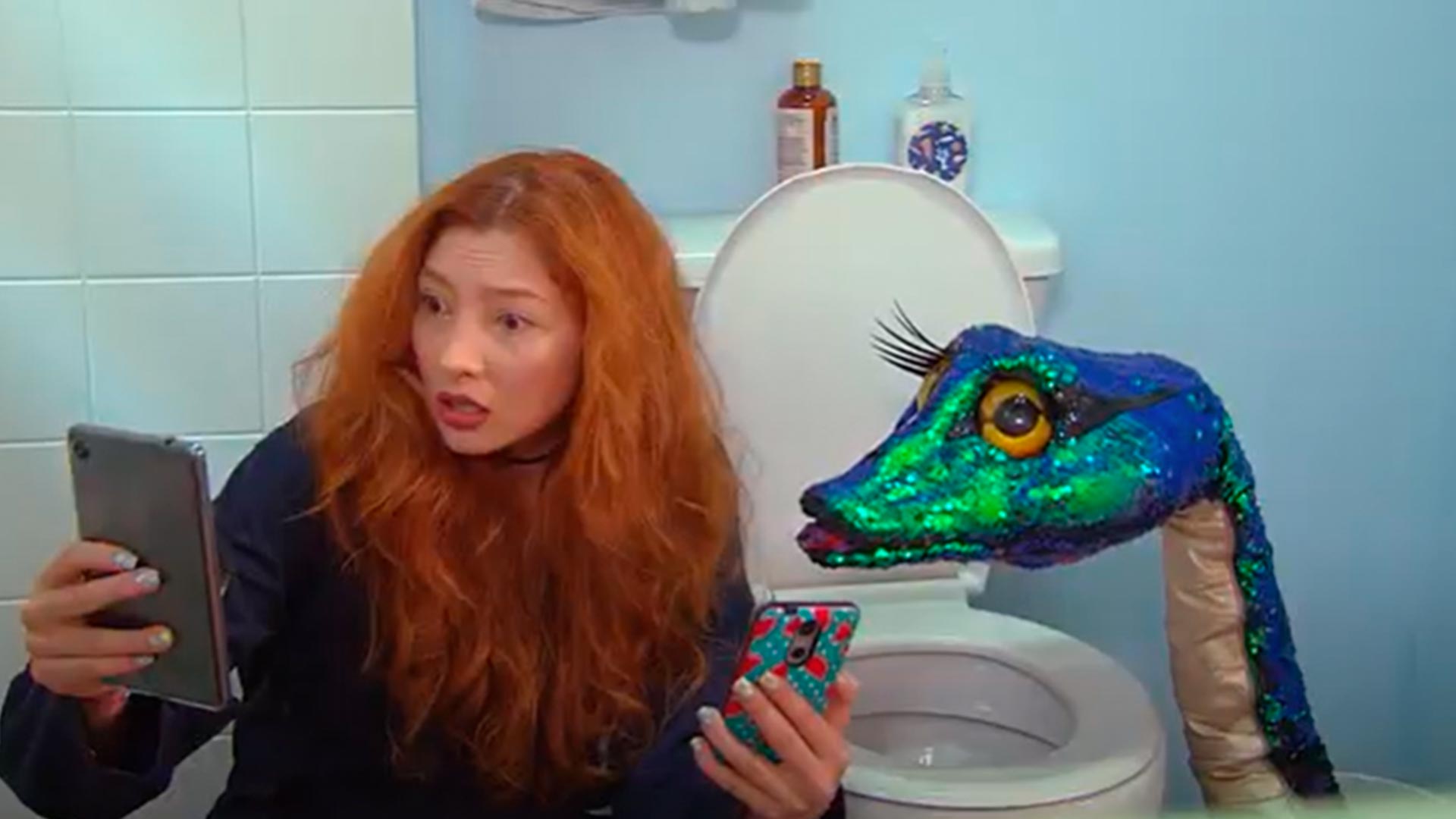 Serpiente de lentejuelas con mujer peliroja mirando el celular 