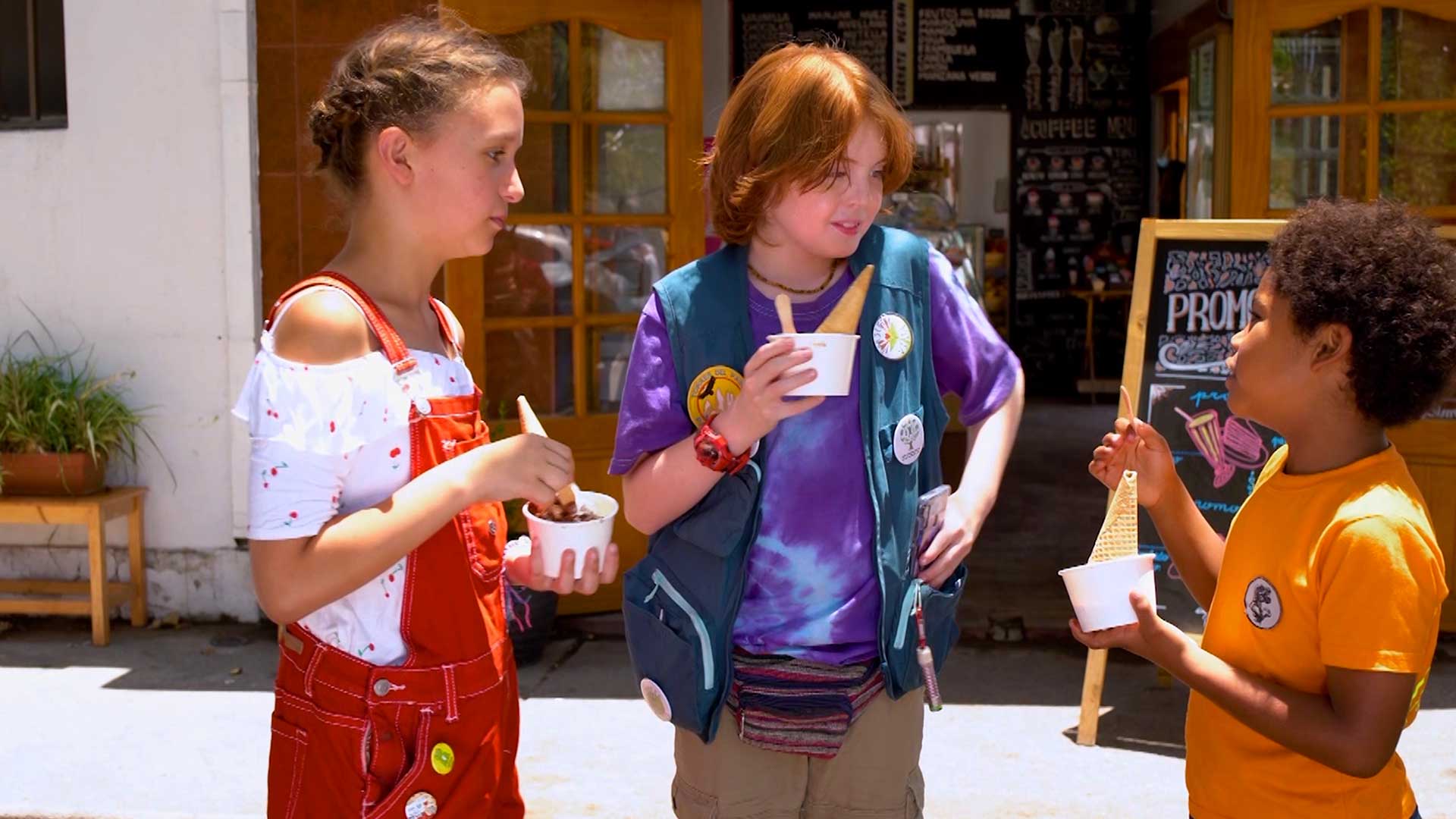 Tres niños exploradores comiendo helado