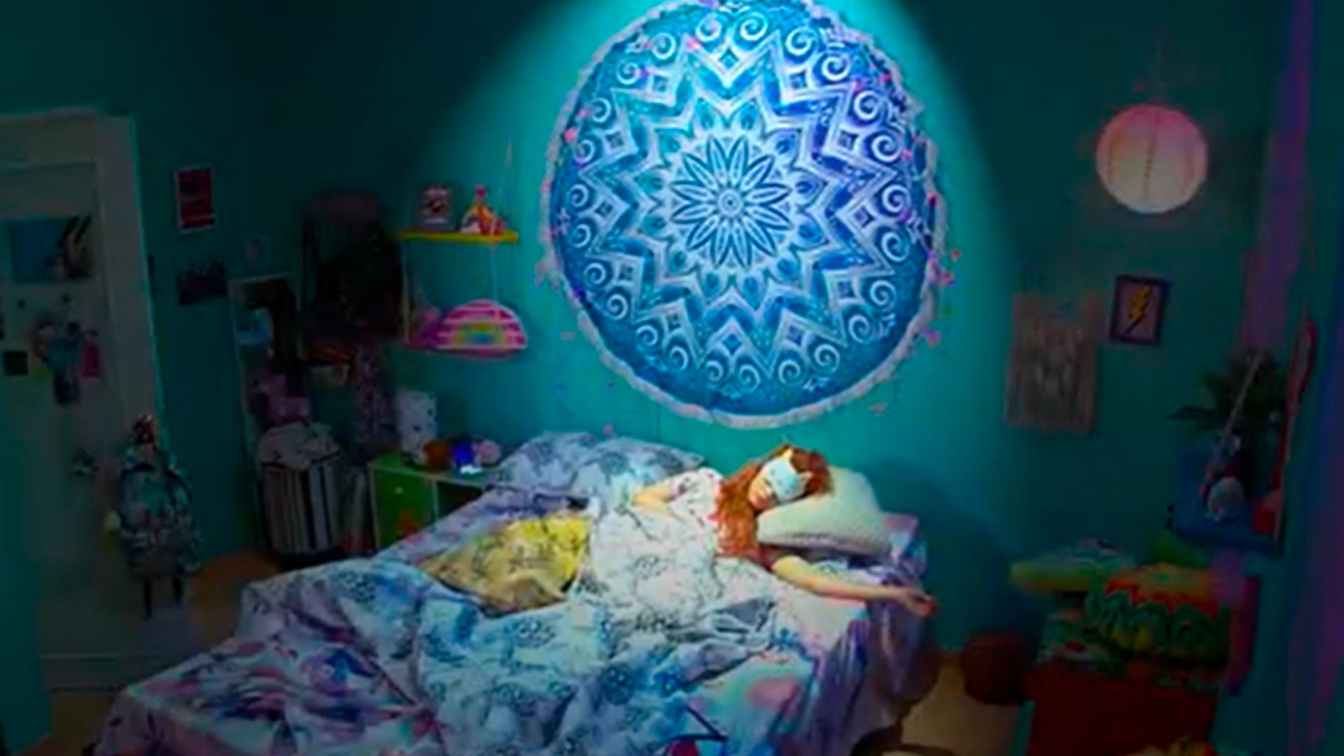niña peliroja dormida en su cuarto con una mandala de cabecera