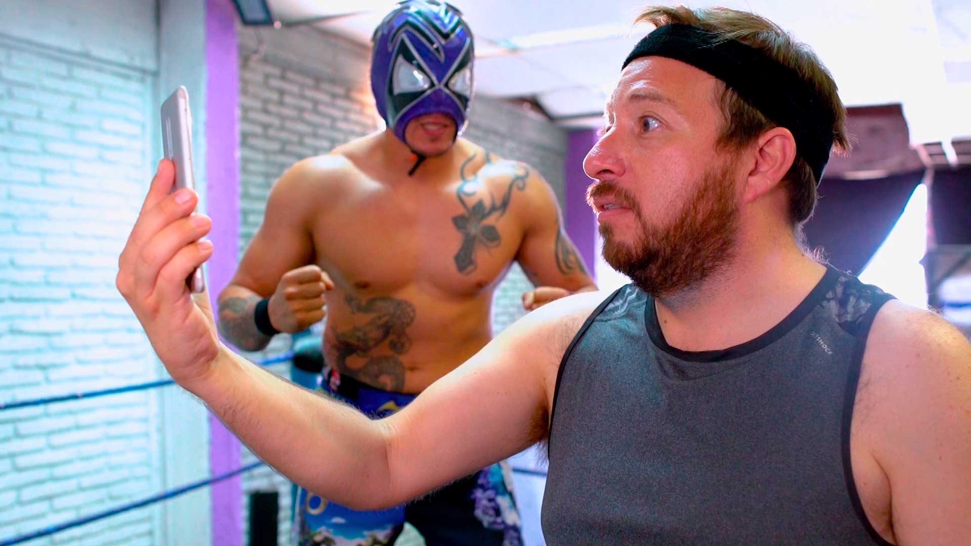 hombre mirando su celular atemorizado por luchador 