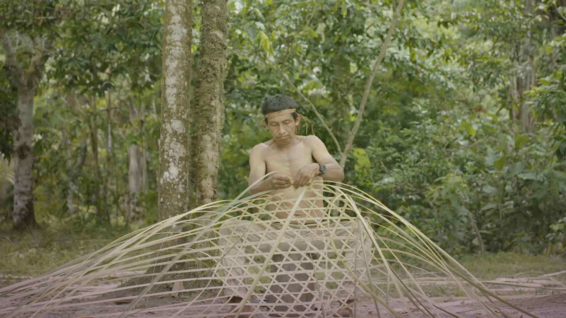 Indígena tejiendo en medio de la selva - Secreto ancestral