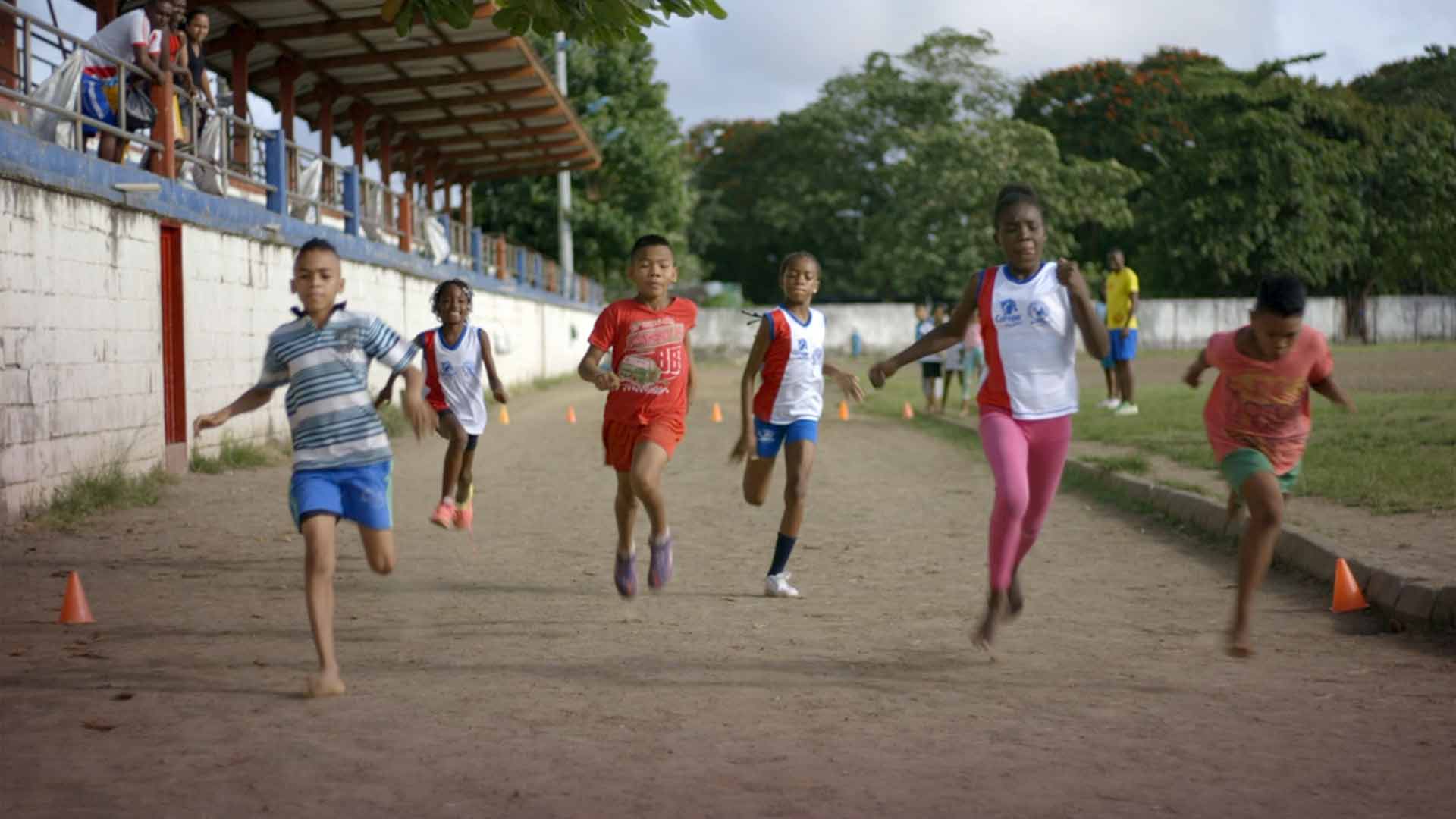 Niños corriendo en una pista de atletismo - En sus marcas