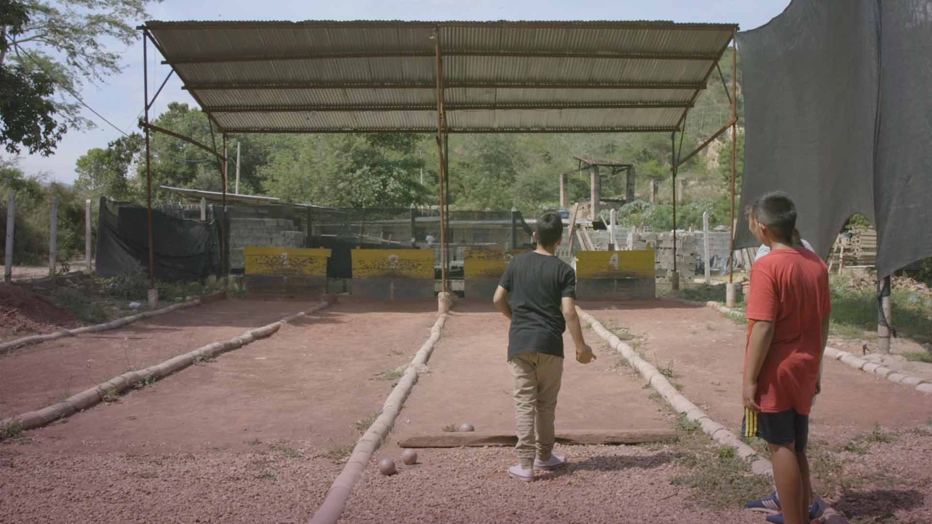 Niños jugando bolo criollo en una cancha en Santander - En sus marcas