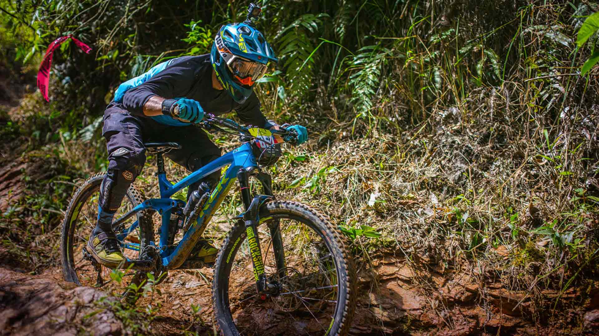 Mujer joven deportista en su bicicleta bajando por una colina - Hijos de la Gaitana