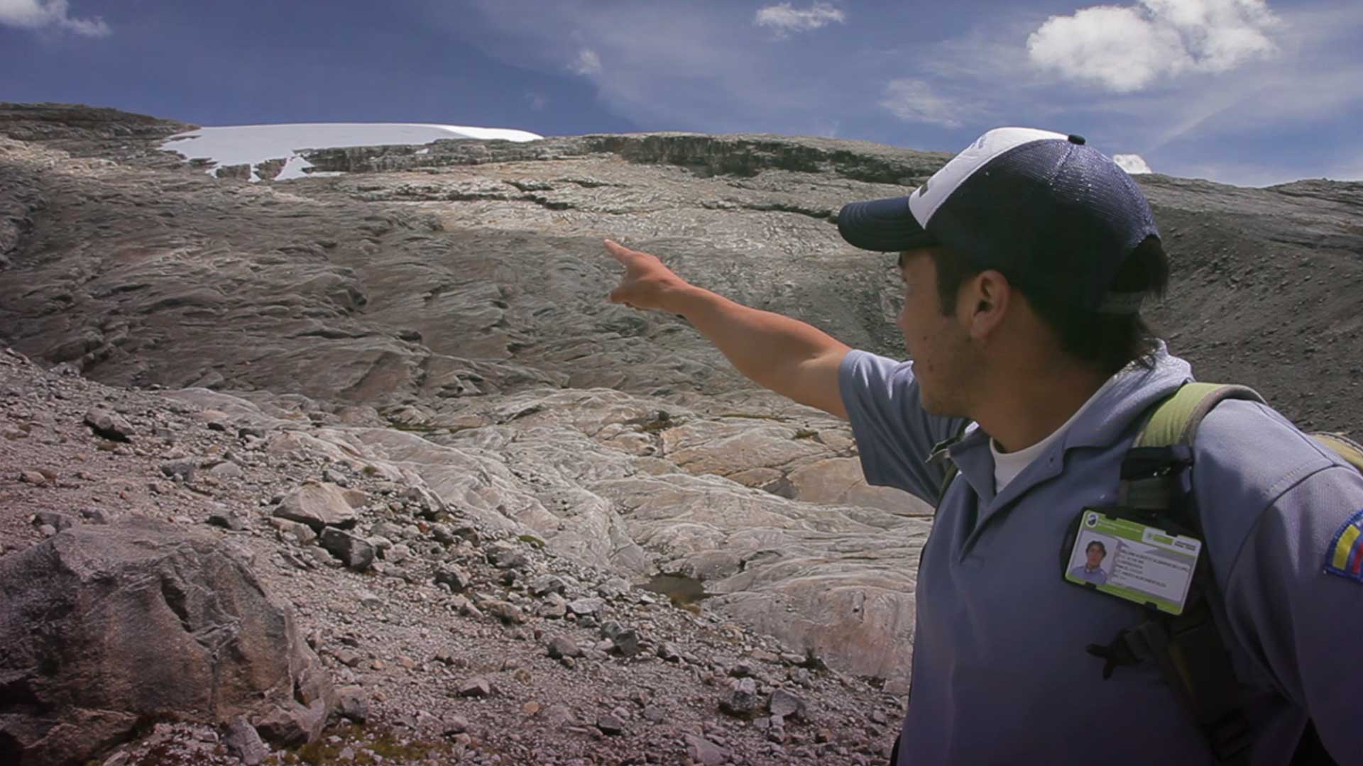 Hombre señalando la nieve en un glaciar - Misión ciencia