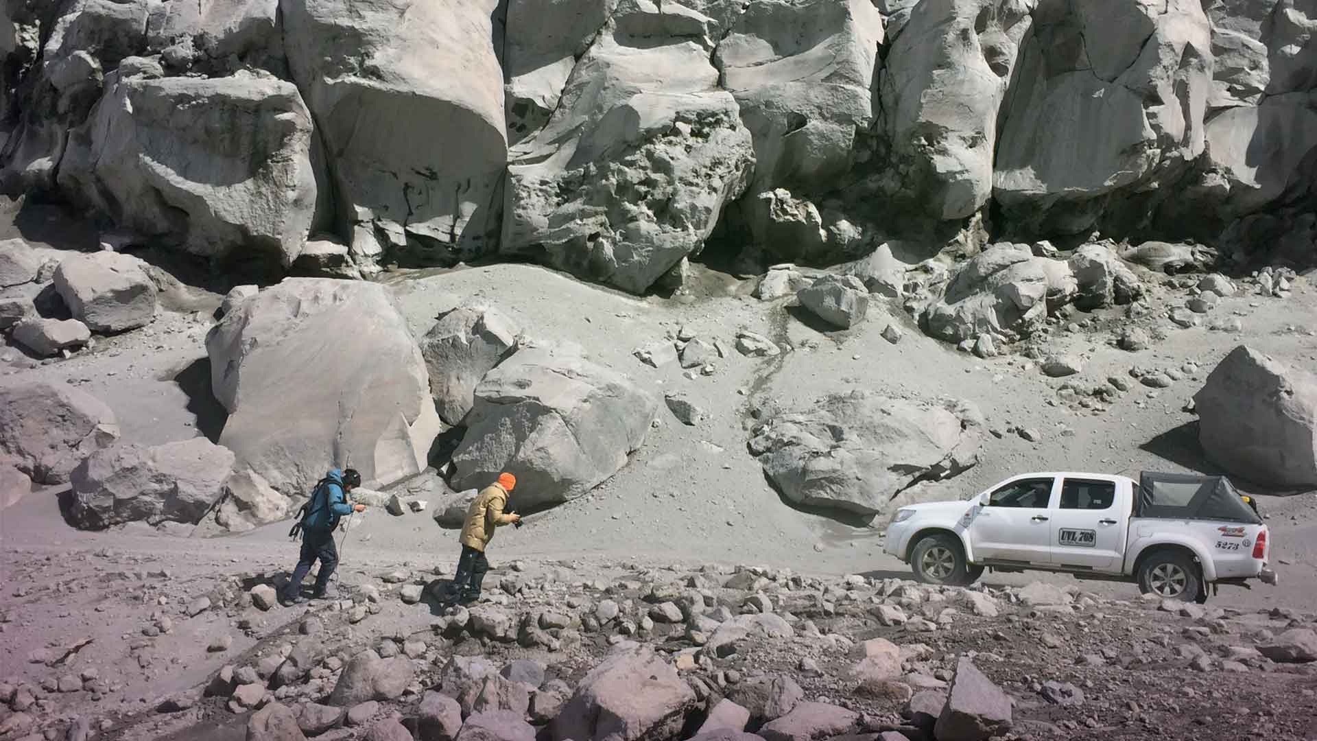 Dos personas caminan sobre un paisaje rocoso (Nevado del Ruiz) - Misión ciencia