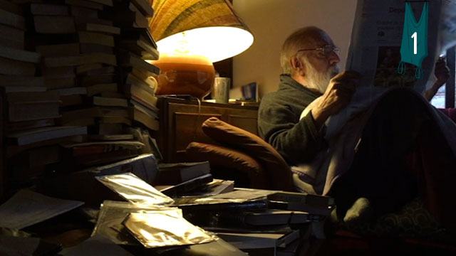 Gustavo Angarita leyendo, rodeado de libros