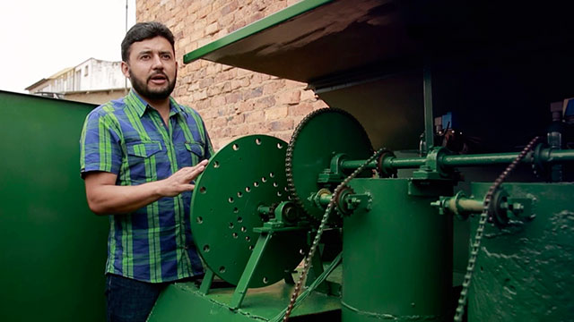 Un hombre junto a una maquina compleja