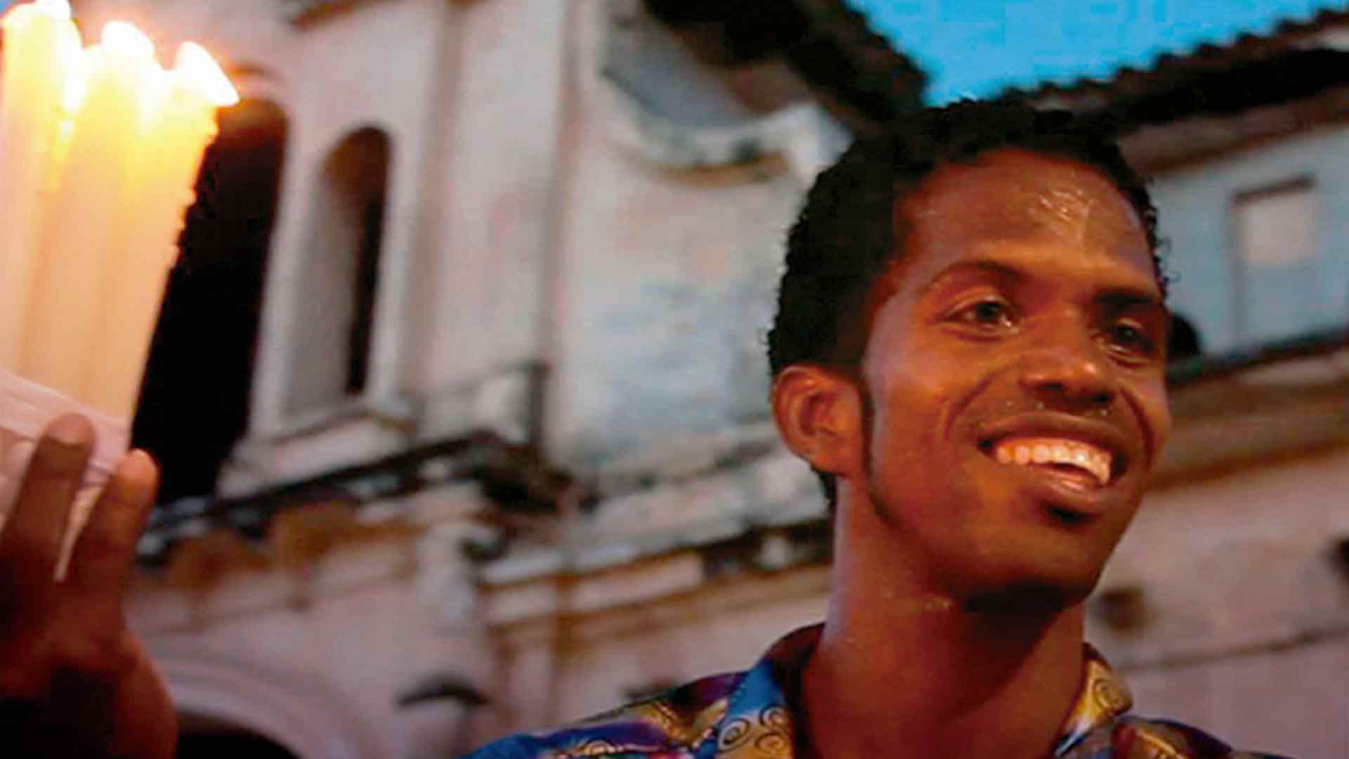 hombre costeño sonriendo con velas en la mano