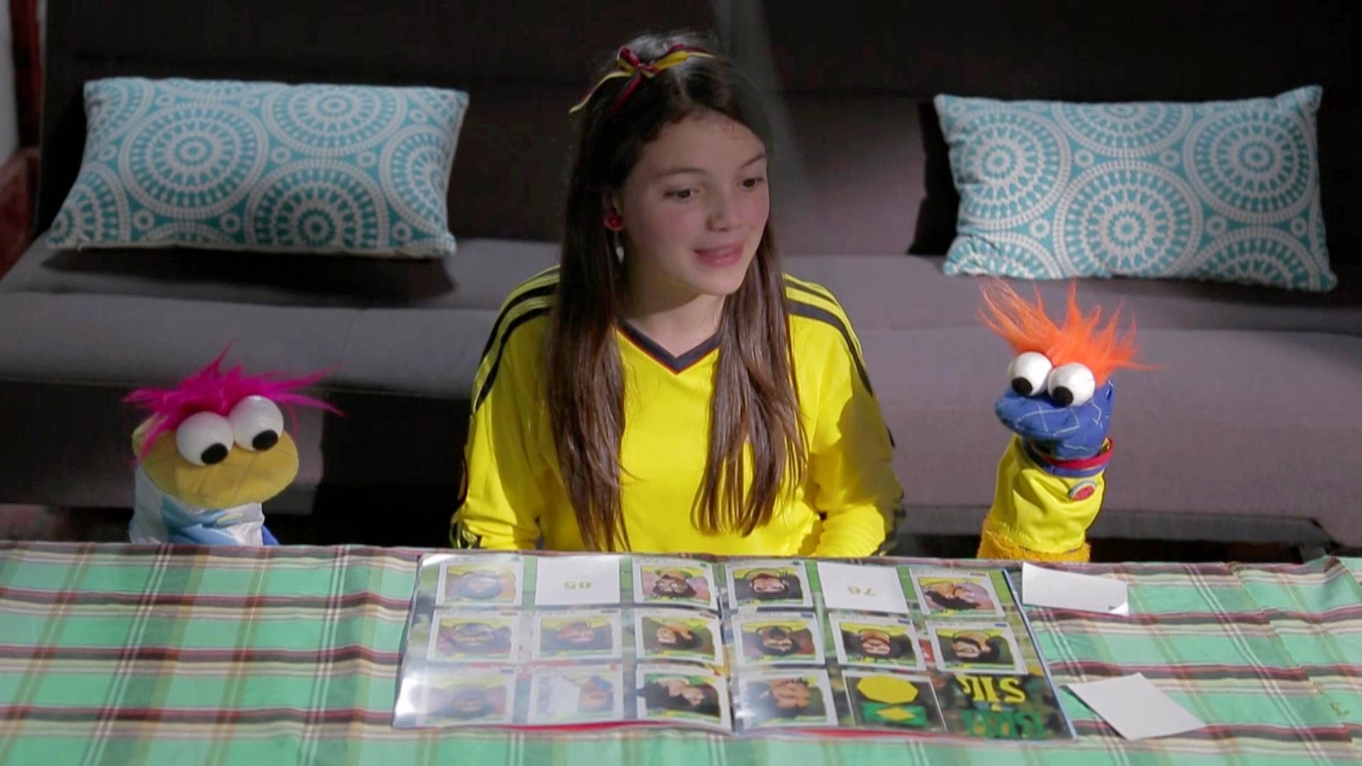 Josefina viendo un álbum de fútbol con los guantes