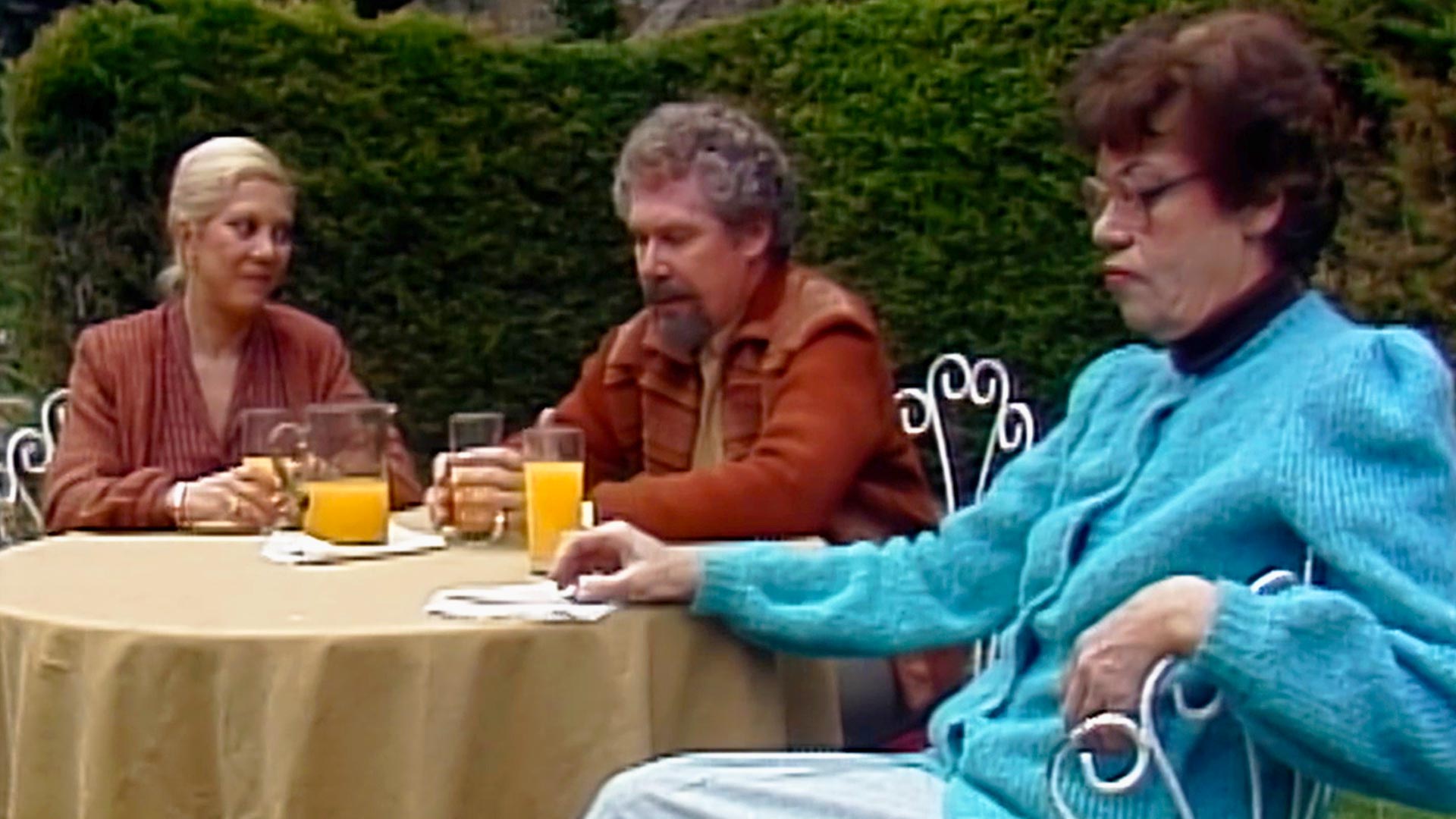 tres personas tomando jugo en el jardín 