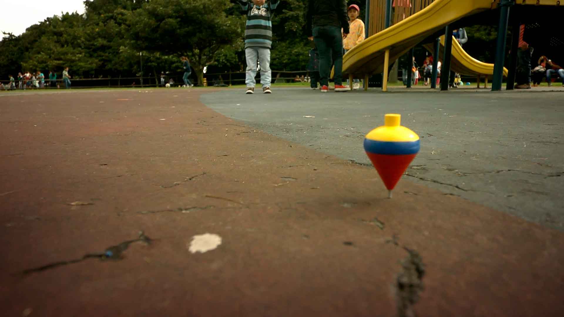 Un trompo de colores amarillo, azul y rojo