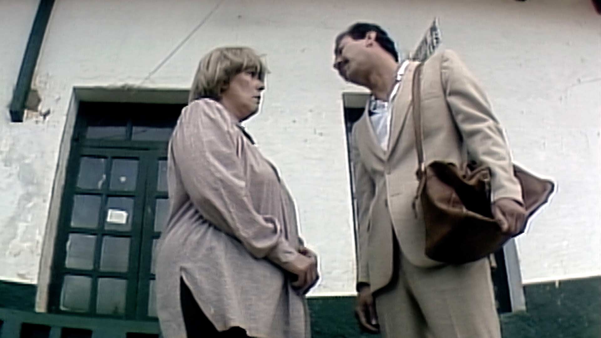 adultos conversando frente a una casa