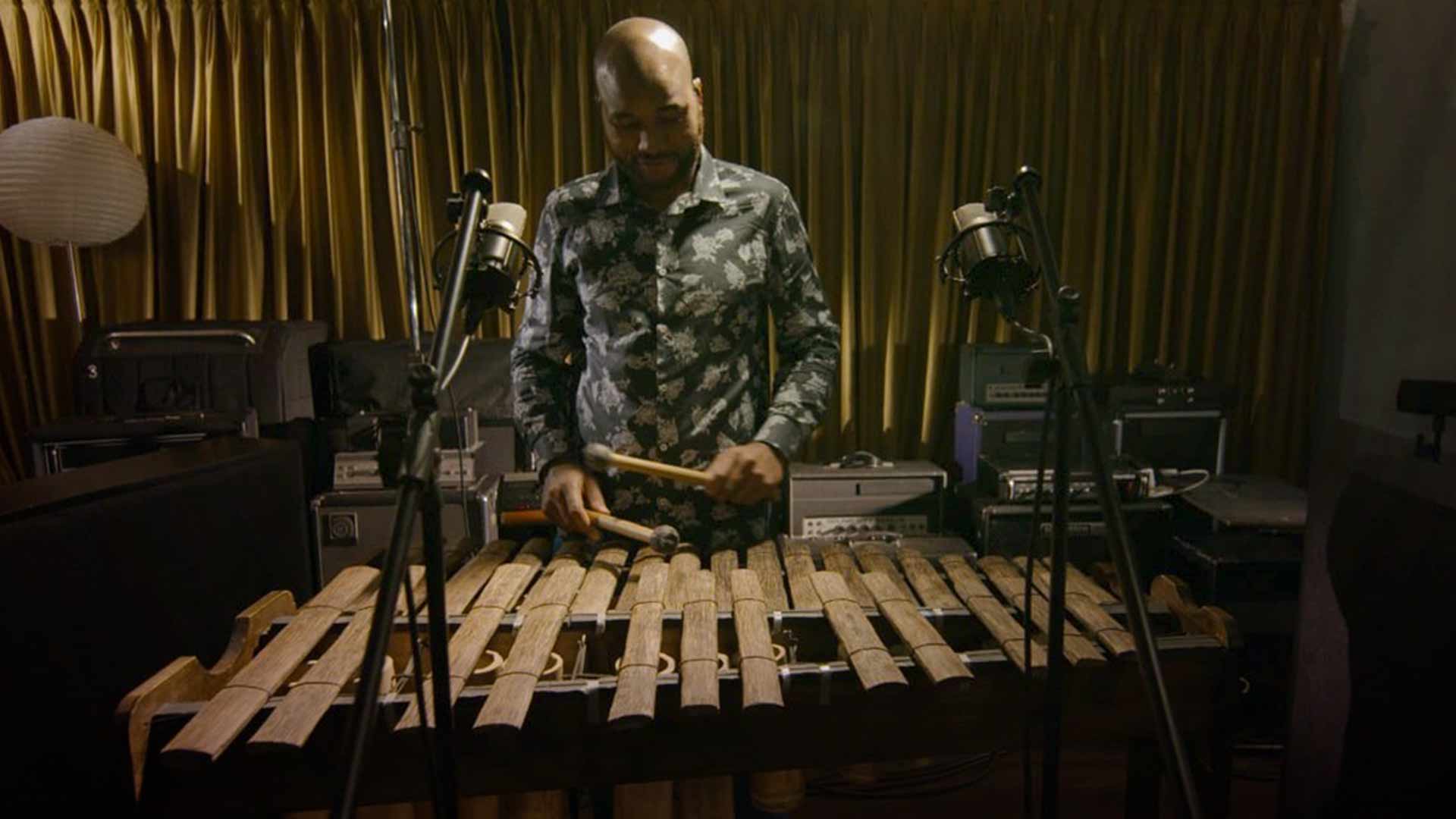 Hombre afro tocando marimba en un estudio musical 