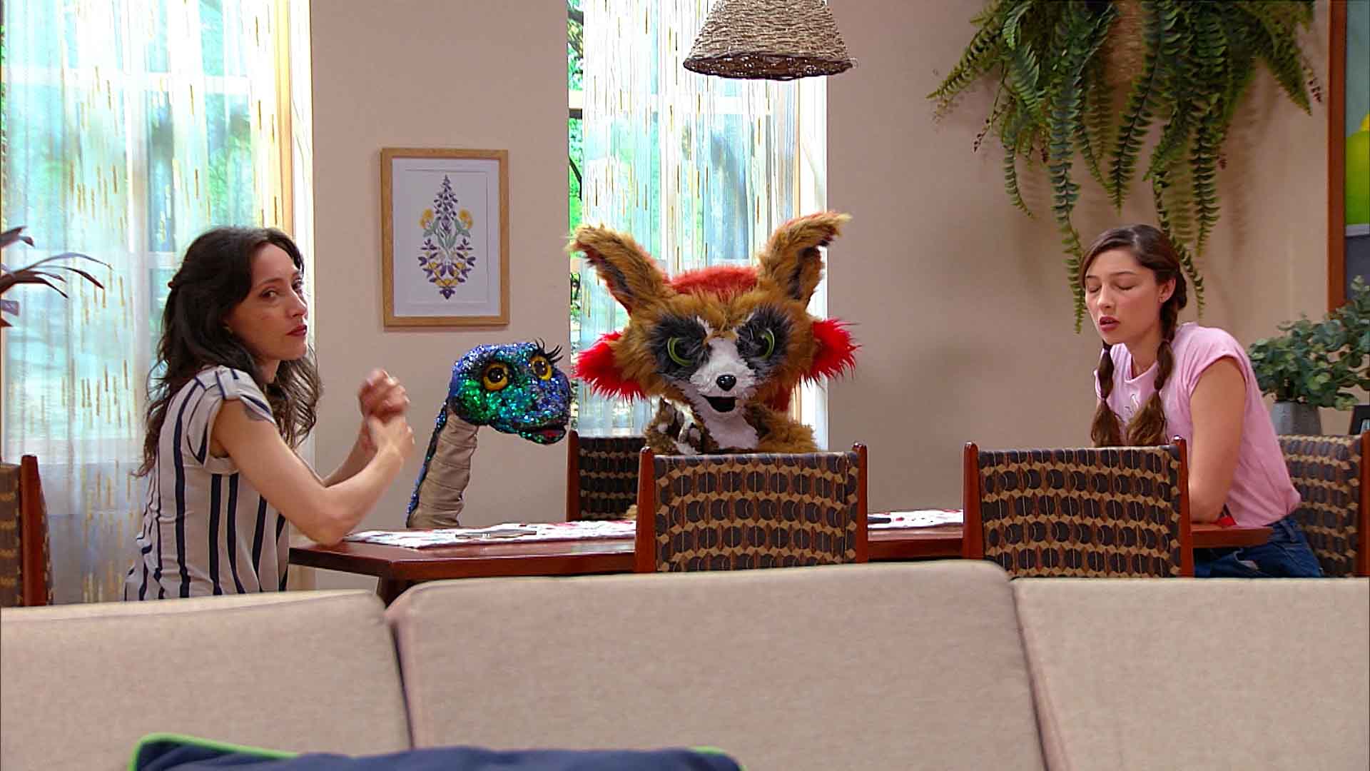 dos mujeres hablando en la mesa con un zorro y una serpiente