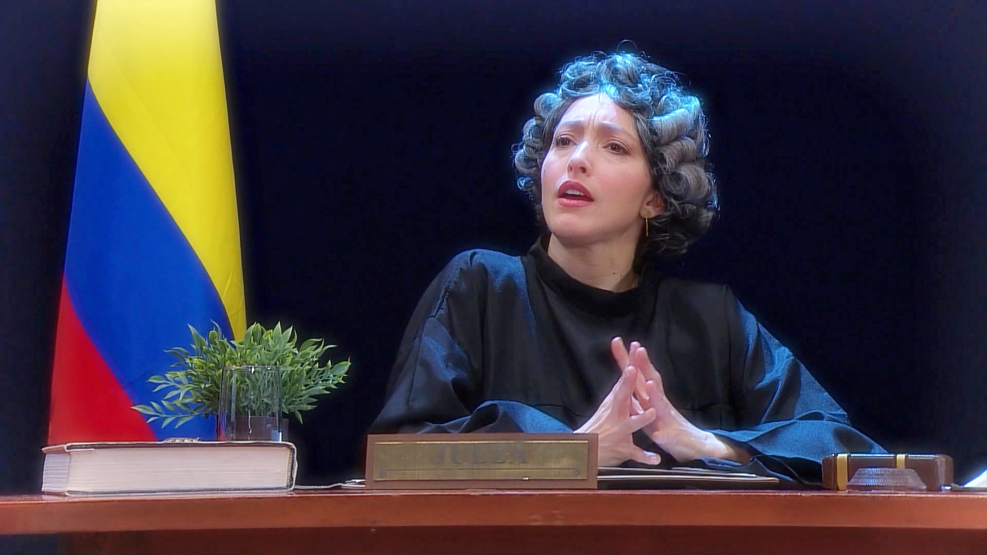 jueza al lado de la bandera de Colombia